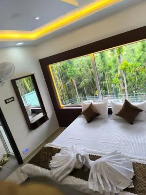 a bedroom with a bed with a large window at wild casa in Kanthalloor