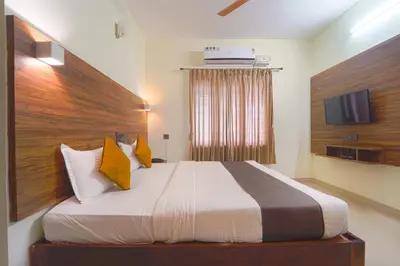 a bedroom with a large bed with a wooden headboard at Chakraa Hotels in Coimbatore