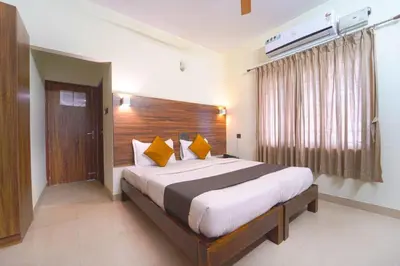 a bedroom with a large bed with yellow pillows at Chakraa Hotels in Coimbatore