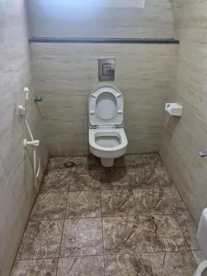 a small bathroom with a toilet in a stall at Chakraa Hotels in Coimbatore