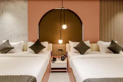 two beds sitting next to each other in a room at Legacy Inn, Mysore in Mysore