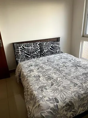 a bed with black and white pillows on top of it at Aarav Stays in Mysore