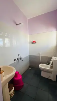 a bathroom with a white toilet and a sink at Mysore Stopover in Mysore