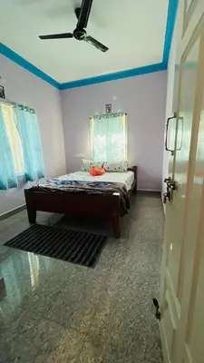 a bedroom with a bed with blue walls and a ceiling at Mysore Stopover in Mysore