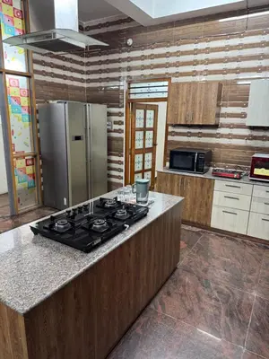 a kitchen with a stove and a refrigerator at LUXE Penthouse 4BHK with Swimming pool in Mysore
