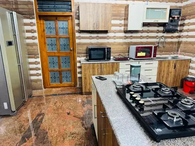 a kitchen with a stove and a counter top at LUXE Penthouse 4BHK with Swimming pool in Mysore