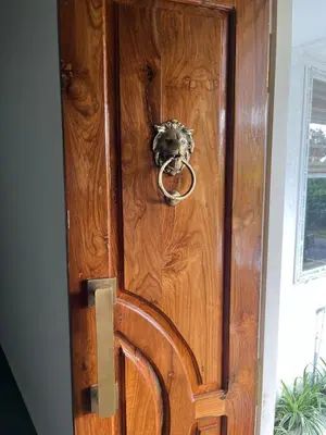 a wooden door with a ring knocker on it at Farmscape Retreat in Gonikoppal