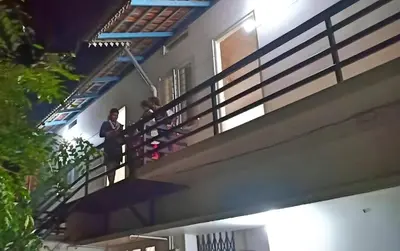 two people standing on the balcony of a building at kadalundi Heritage in Vallikunnu