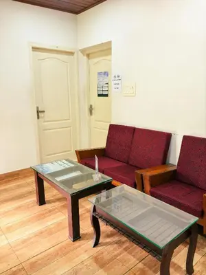 a living room with two red couches and a coffee table at kadalundi Heritage in Vallikunnu