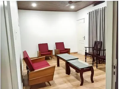 a waiting room with red chairs and a table at kadalundi Heritage in Vallikunnu