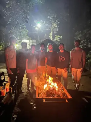 a group of men standing around a fire at Organic Farmers Tent & Trekking in Yedapalli