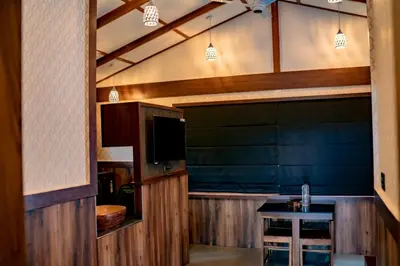 a living room with a television and a table at Daya Village in Tirūrangādi