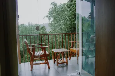 a balcony with a table and a chair and a table at Daya Village in Tirūrangādi