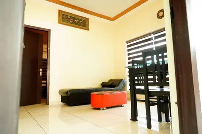 a living room with a black couch and a red suitcase at Daya Village in Tirūrangādi
