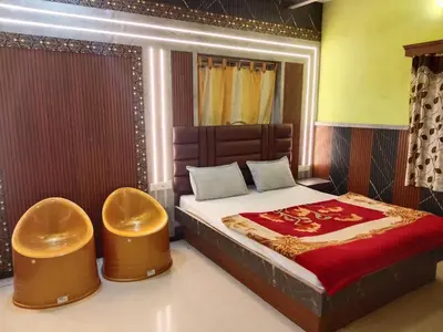a bedroom with a large bed with two stools at Sri Krishna residency in Ooty