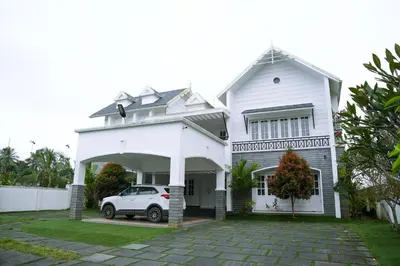 a white house with a car parked in the driveway at The Glen By Bloobuck in Ambalavayal
