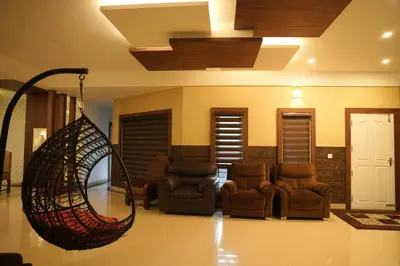 a living room with chairs and a hanging hammock at The Glen By Bloobuck in Ambalavayal