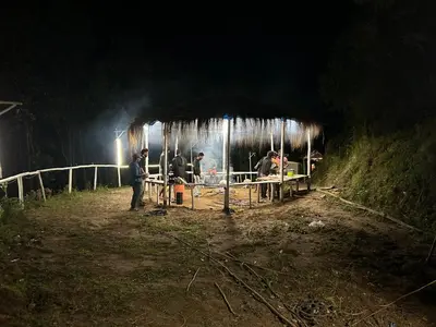 a group of people standing in a hut at night at Mystic Valley Vattavada in Vattavada