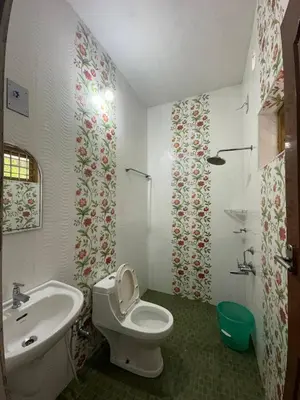 a bathroom with a toilet and a sink at Villa Tharavadu in Angamali