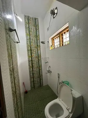 a bathroom with a toilet and a shower at Villa Tharavadu in Angamali