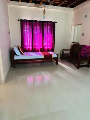 a room with a bed and a pink window at Festoon Villa in Sultan Bathery