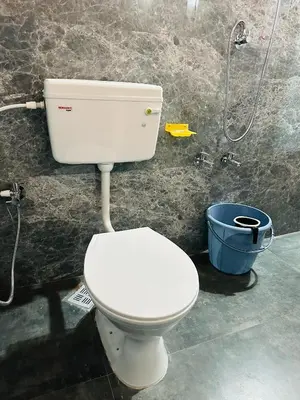a bathroom with a white toilet and a bucket at Festoon Villa in Sultan Bathery