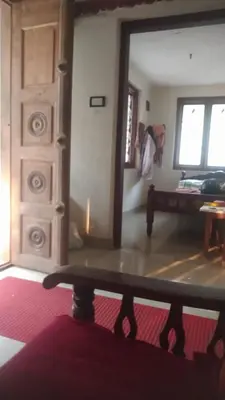 a living room with a mirror and a bed and a table at ARAVON Homes in Meenangadi