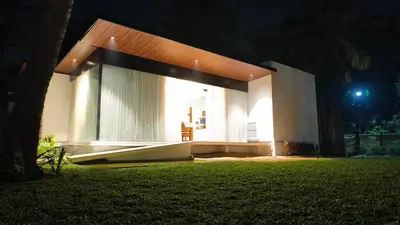 a large white house at night with a green lawn at Reflections by SOL Escapes near Cherai Beach in Pallipuram