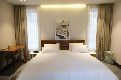 a bedroom with a large white bed and a desk at Reflections by SOL Escapes near Cherai Beach in Pallipuram