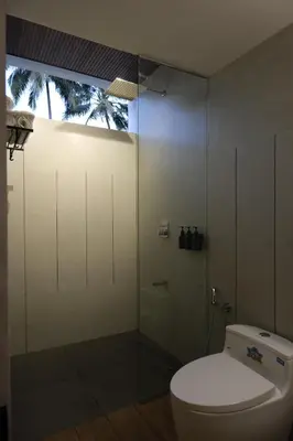 a bathroom with a toilet and a glass shower at Reflections by SOL Escapes near Cherai Beach in Pallipuram