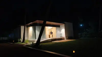 a house at night with a tree in front of it at Reflections by SOL Escapes near Cherai Beach in Pallipuram