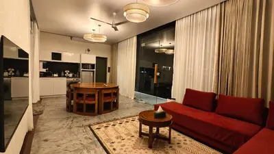 a living room with a red couch and a table at Reflections by SOL Escapes near Cherai Beach in Pallipuram