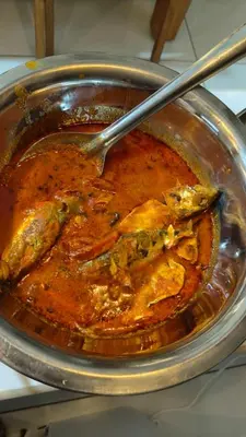 a bowl of food with a spoon in it at South point homestay in Virajpet