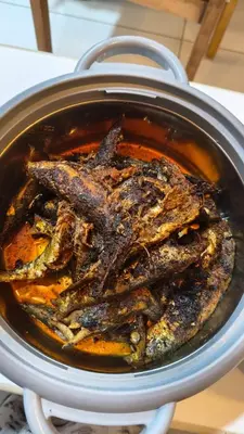 a pot of soup with a fish in it at South point homestay in Virajpet