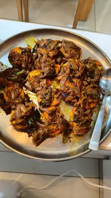 a plate of food with meat and vegetables on a table at South point homestay in Virajpet