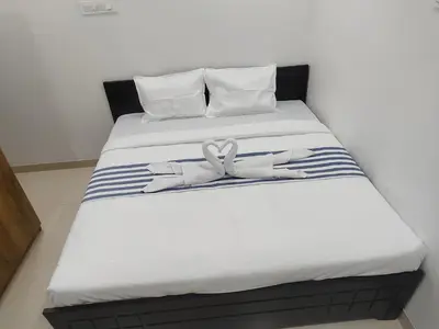 a bed with two white towels on top of it at Goldwins Grand A comfort stay in Coimbatore
