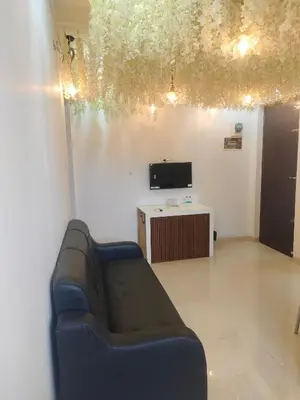 a living room with a couch and a tv at Goldwins Grand A comfort stay in Coimbatore