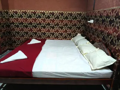 a bed with red and white sheets and pillows at Kanthalloor Mud & Mist Homestay in Kanthalloor