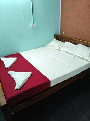 a bed with a red blanket and white pillows at Kanthalloor Mud & Mist Homestay in Kanthalloor