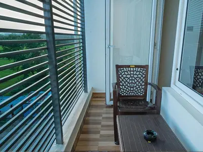 a balcony with a chair and a window with blinds at New SK Residency Mysore in Mysore