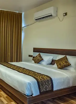 a bedroom with a large bed with white sheets and pillows at New SK Residency Mysore in Mysore