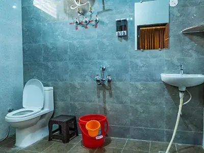 a bathroom with a toilet and a sink at New SK Residency Mysore in Mysore