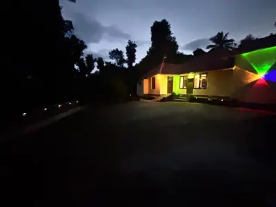 a house lit up at night with a green light at KODIYADAN s INN A Homestay with a Heart in Meenangadi