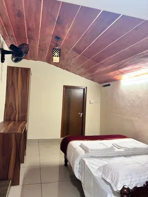 a bedroom with a bed and a wooden ceiling at KODIYADAN s INN A Homestay with a Heart in Meenangadi