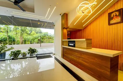 an office lobby with a reception desk and a large window at Super Townhouse Cochin Airport Formerly Skyluxe in Cochin