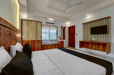 a bedroom with a large bed and a flat screen tv at Super Townhouse Cochin Airport Formerly Skyluxe in Cochin