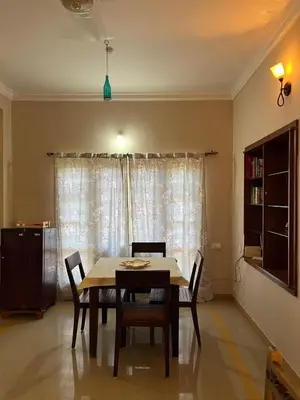a dining room with a table and chairs and a window at Mulberry Bay Serviced Apartments in Mysore
