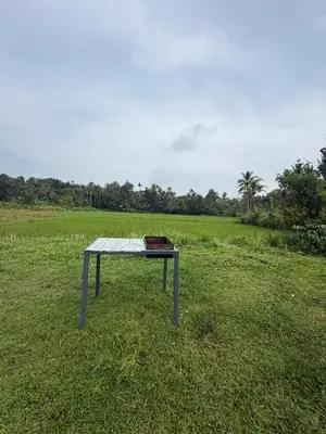 a table sitting in the middle of a field at Nanavu Farmhouse in Māla