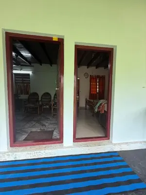 a room with two sliding glass doors and a living room at Nanavu Farmhouse in Māla