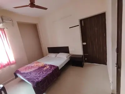 a bedroom with a bed and a brown door at Union Rooms in Coimbatore
